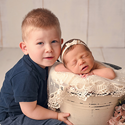 baby boy holding his baby sister